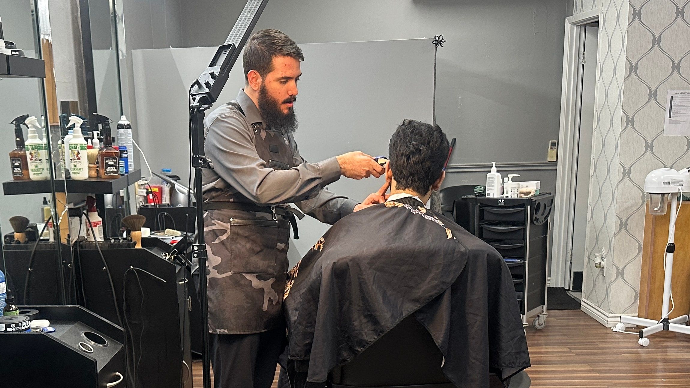 Barber cutting a client’s hair in the shop